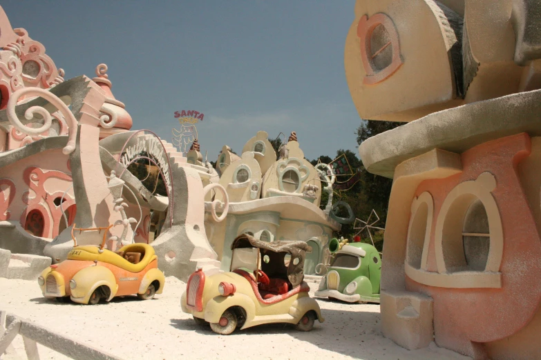 several colorful model houses and cars at a theme park