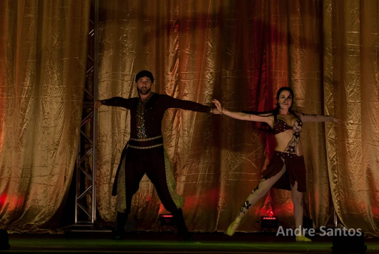 two dancers dancing on stage, one holding the other arms out