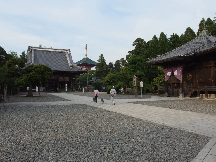 two people walking through an area lined with rocks and gravel