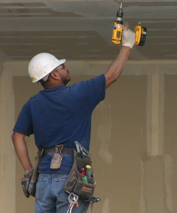 a man with drillers and working gloves on his shoulders