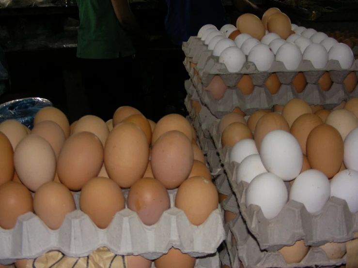 several boxes filled with eggs and a woman standing near them