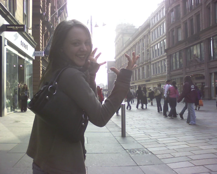 a woman making a hand signal on the street