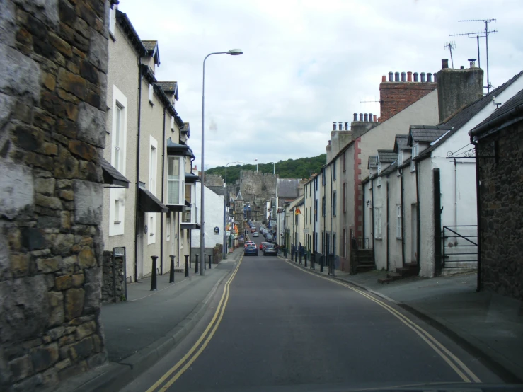 a street lined with buildings next to a hill
