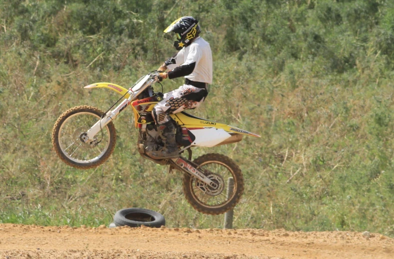 a person doing a wheelie over a dirt road