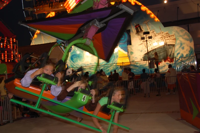 people at an amut park with a rainbow theme park ride