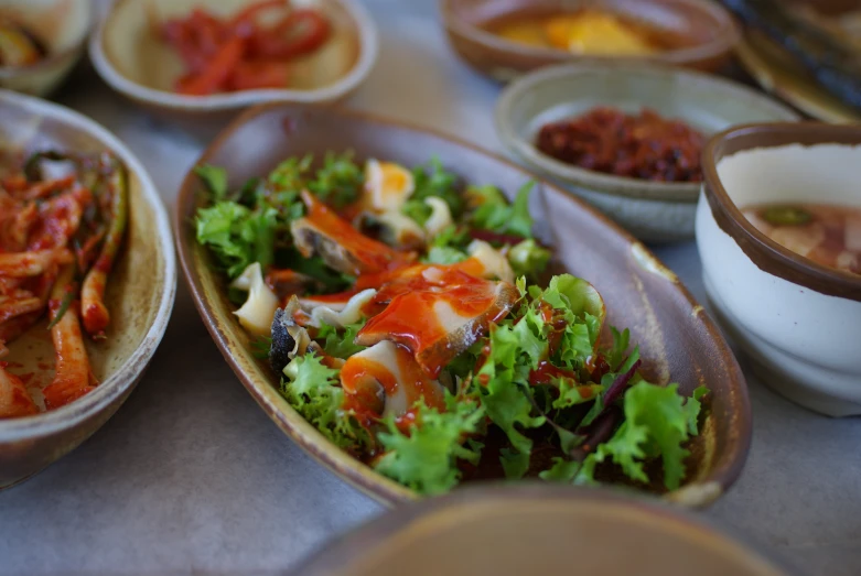 a table set with many plates with food and bowls on the tables