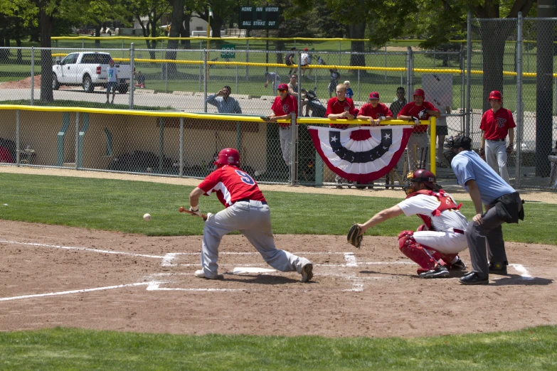 the batter is sliding into home plate as the catcher and umpire watch