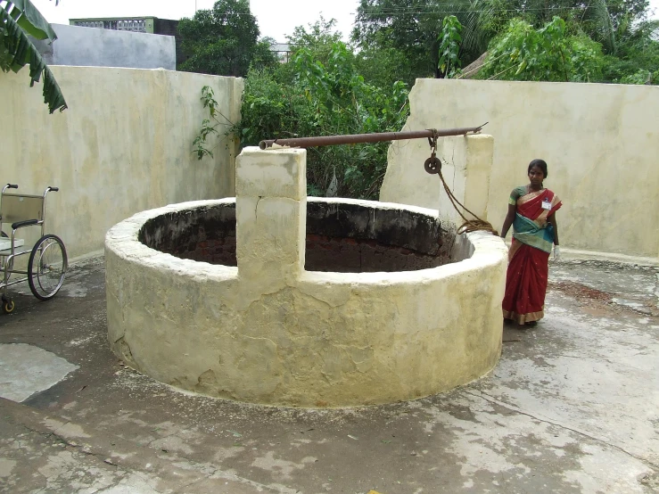 a woman in her village uses a water pump