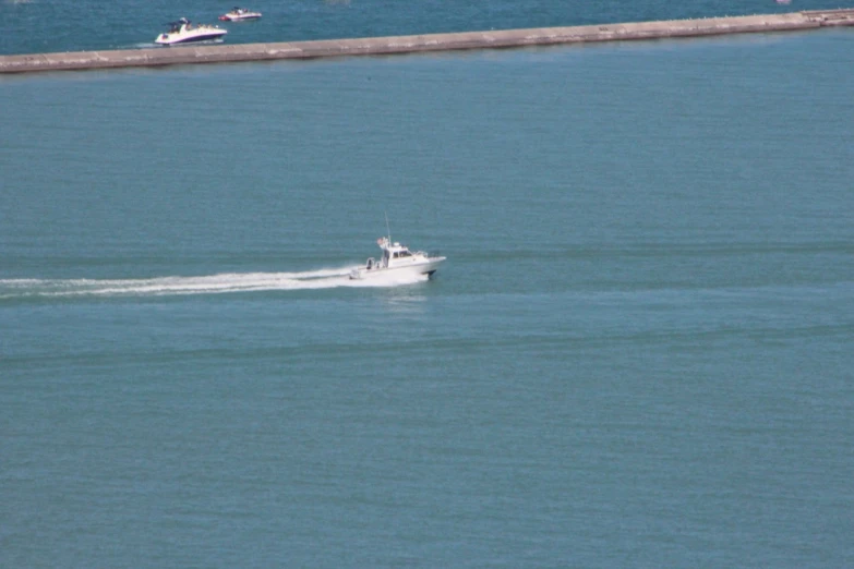 boat moving fast on water near concrete wall