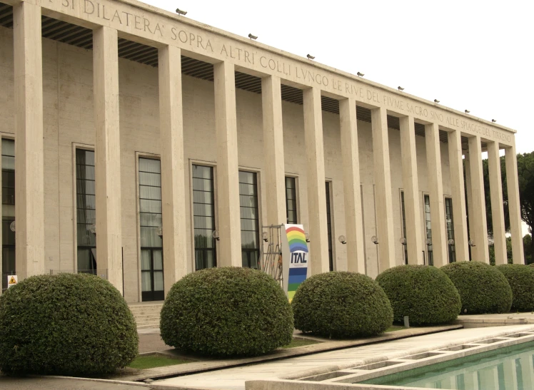 a building with pillars and plants in front of it