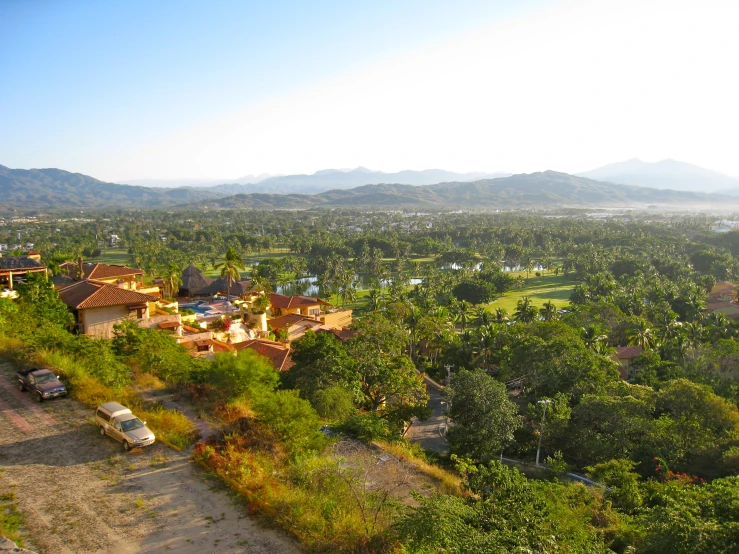 view over the road from above a hill to the green valley and town