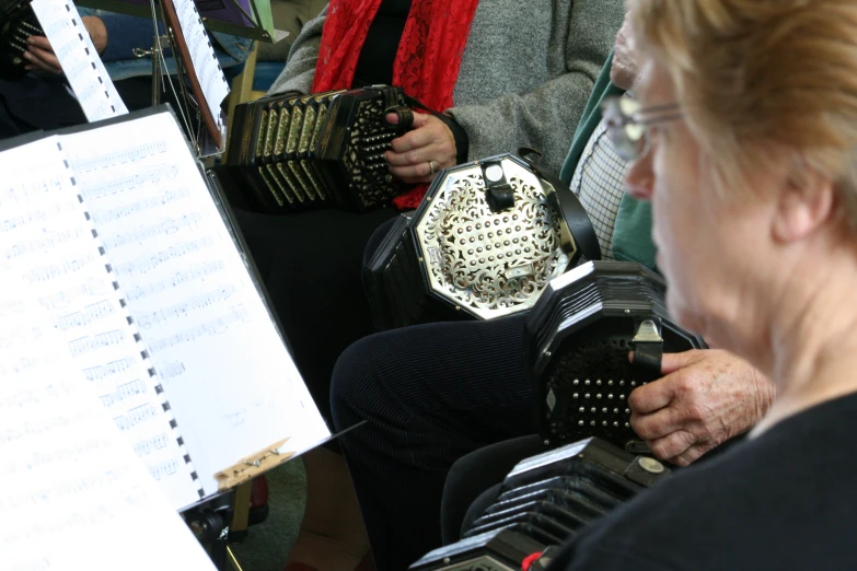 a woman playing an accordian in front of two accordion players