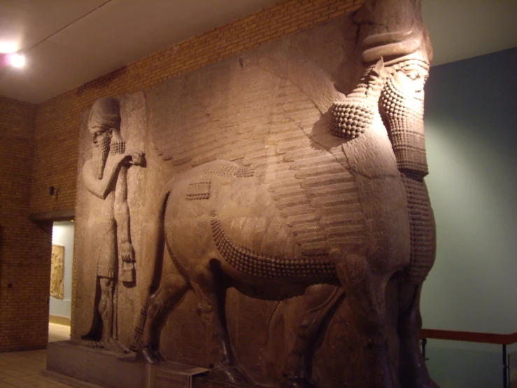 a large sculpture of an animal and a man standing next to it