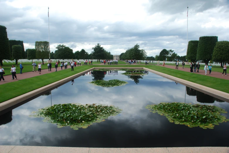 the large pond on the grounds is surrounded by a lush green garden