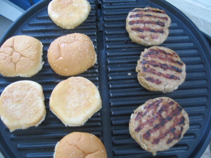 a close up of a grill with hamburgers and burger patties