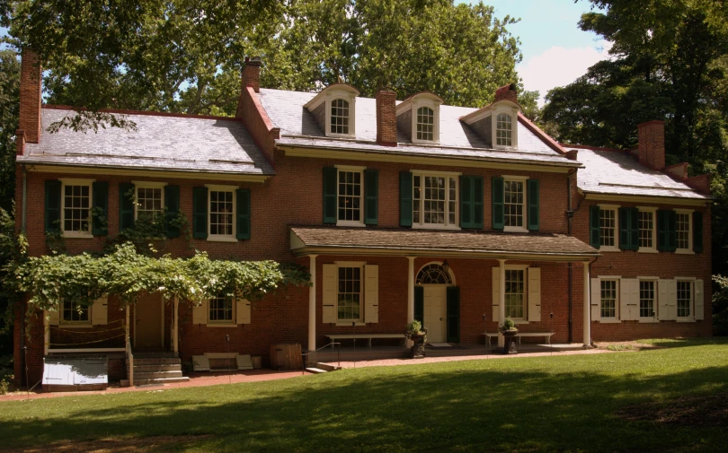 an old brick house with large windows and shutters