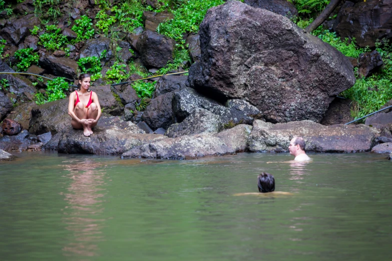 man sitting on rock in a body of water