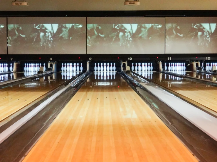 the bowling alley in a bowling facility has rows of bowling equipment