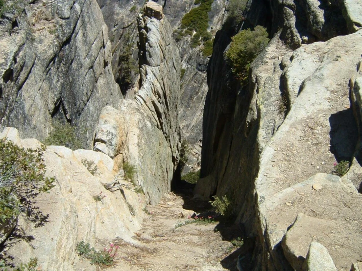 a narrow mountain trail surrounded by very large rocks