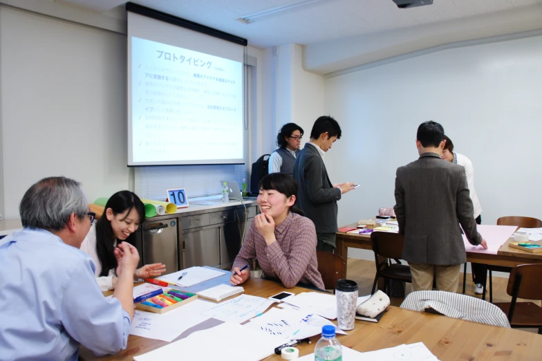 a group of people standing around a table