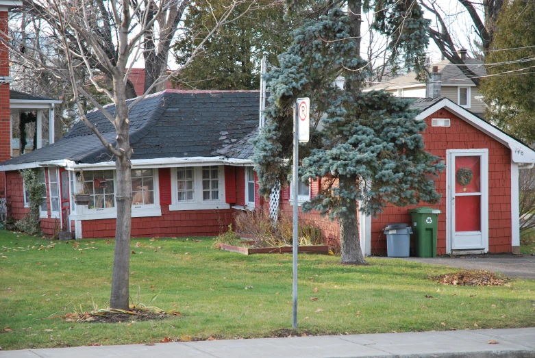 a red building with white trim and a green tree