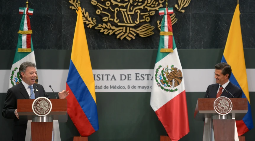 two men standing at podiums in front of mexican flags