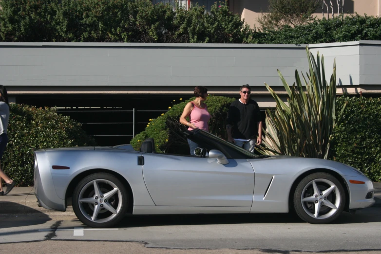 a silver sports car parked on the side of a road