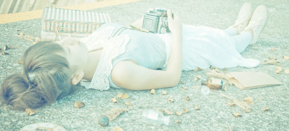 a woman laying down on the ground next to a book