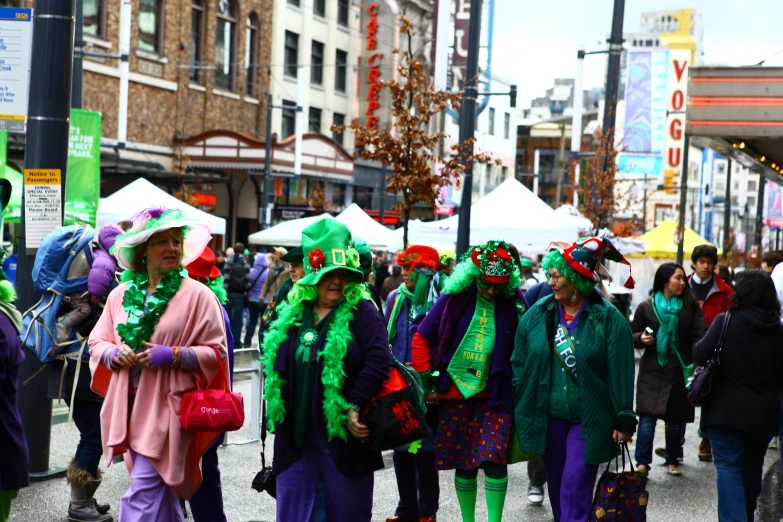 many people in costumes walk down the street