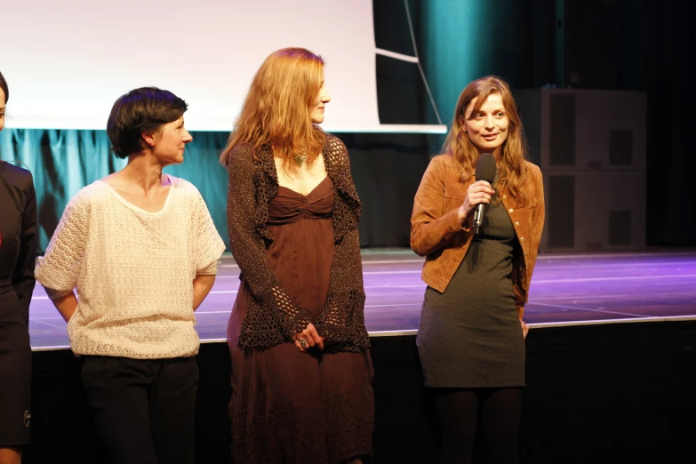 a group of young people standing in front of a stage