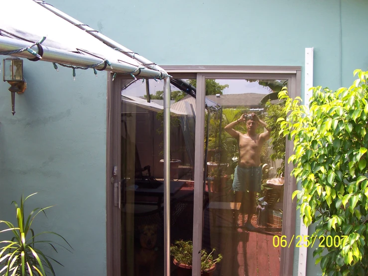 a man wearing  standing behind glass doors