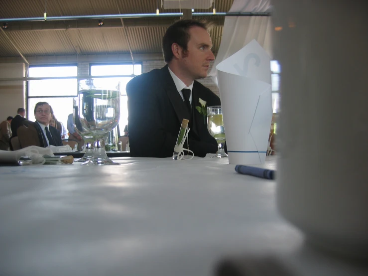 a man sits at a table in front of a wine glass