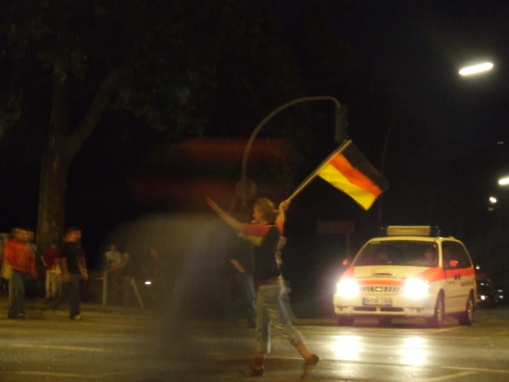 a man with a flag on his arm waves in the air at night