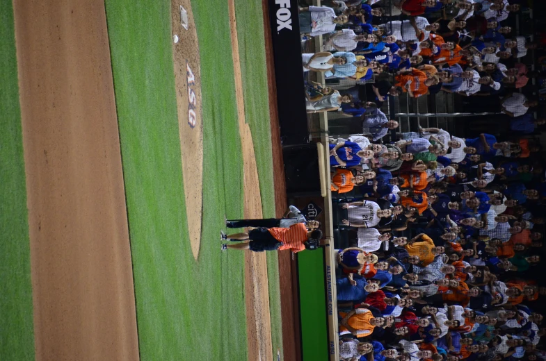 the crowd watches a baseball player throw a pitch