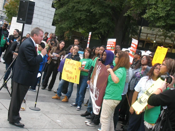 a man standing on top of a sidewalk with many signs