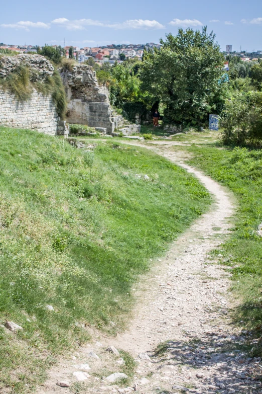 the dirt path leads to a small town