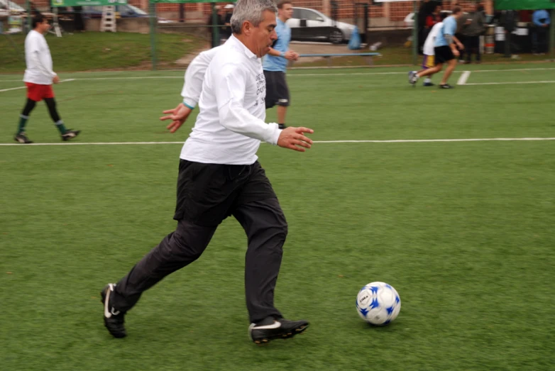 a man is kicking a soccer ball on the field