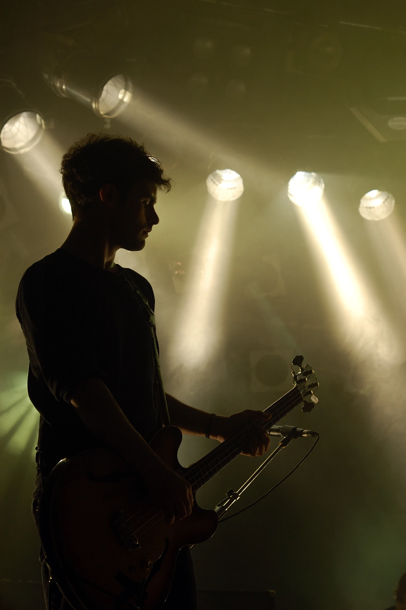 a man holding a guitar on stage with many lights