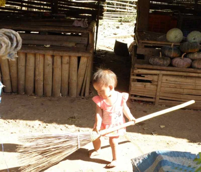a  holding onto a broom in the sand