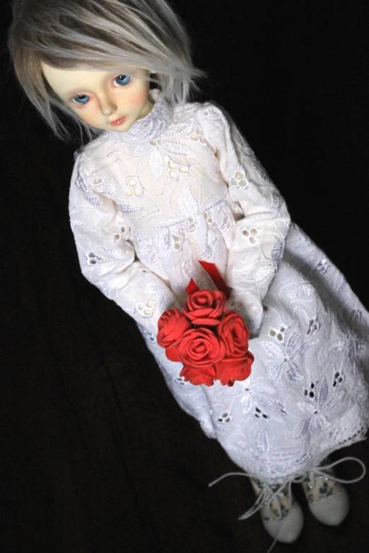the doll is wearing a white dress with flowers