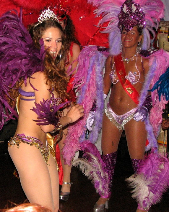 two women dressed in colorful costumes standing on stage