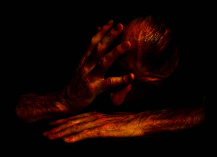 a man holding his hands over his face as if he was in the dark