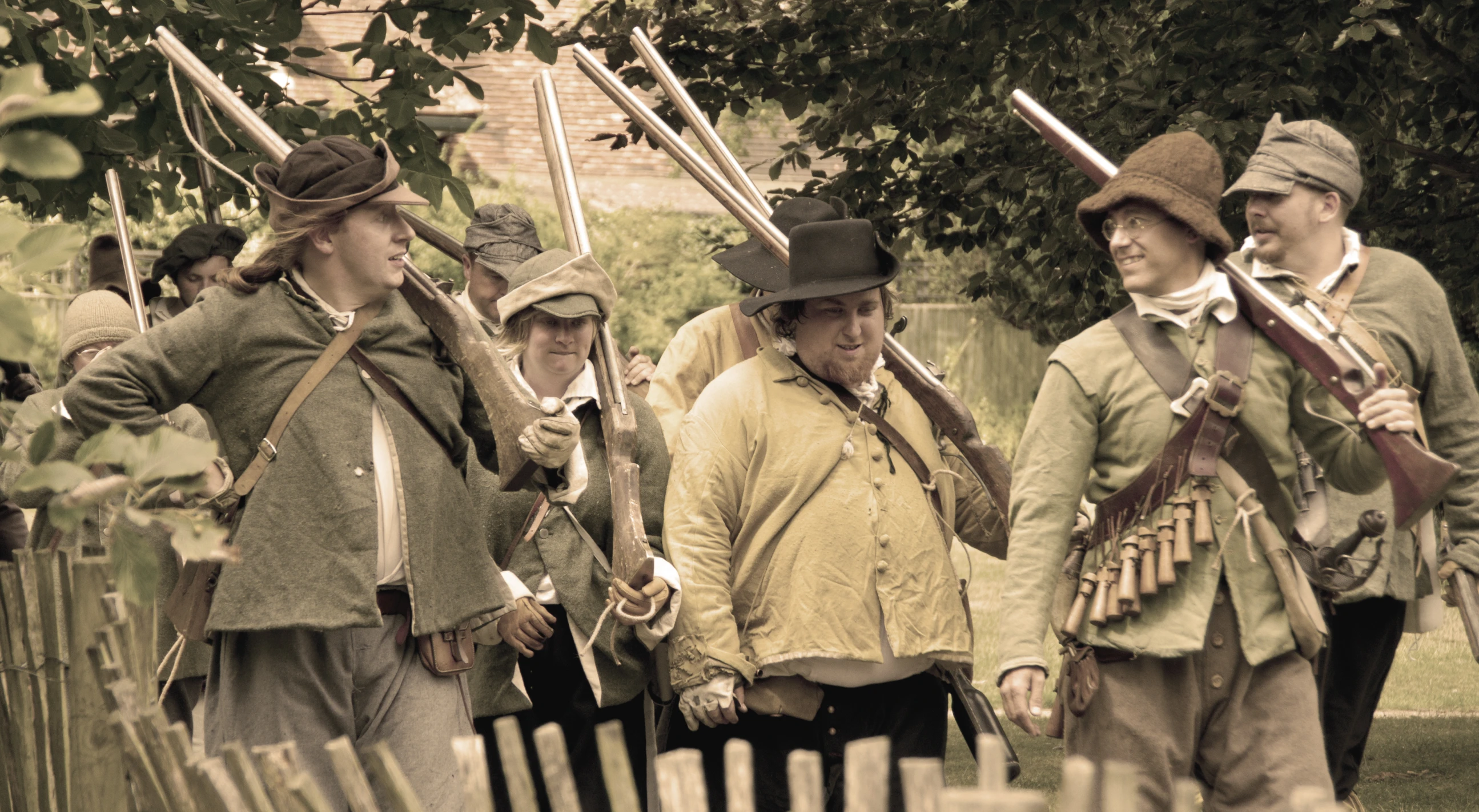 men in period outfits, holding weapons and pointing them