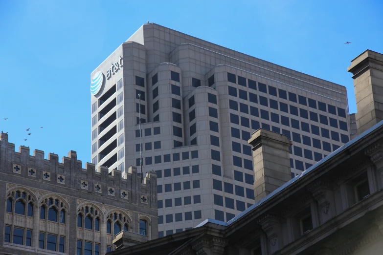 tall buildings are next to each other with birds flying overhead