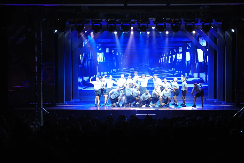 several men with their backs turned on stage for a performance