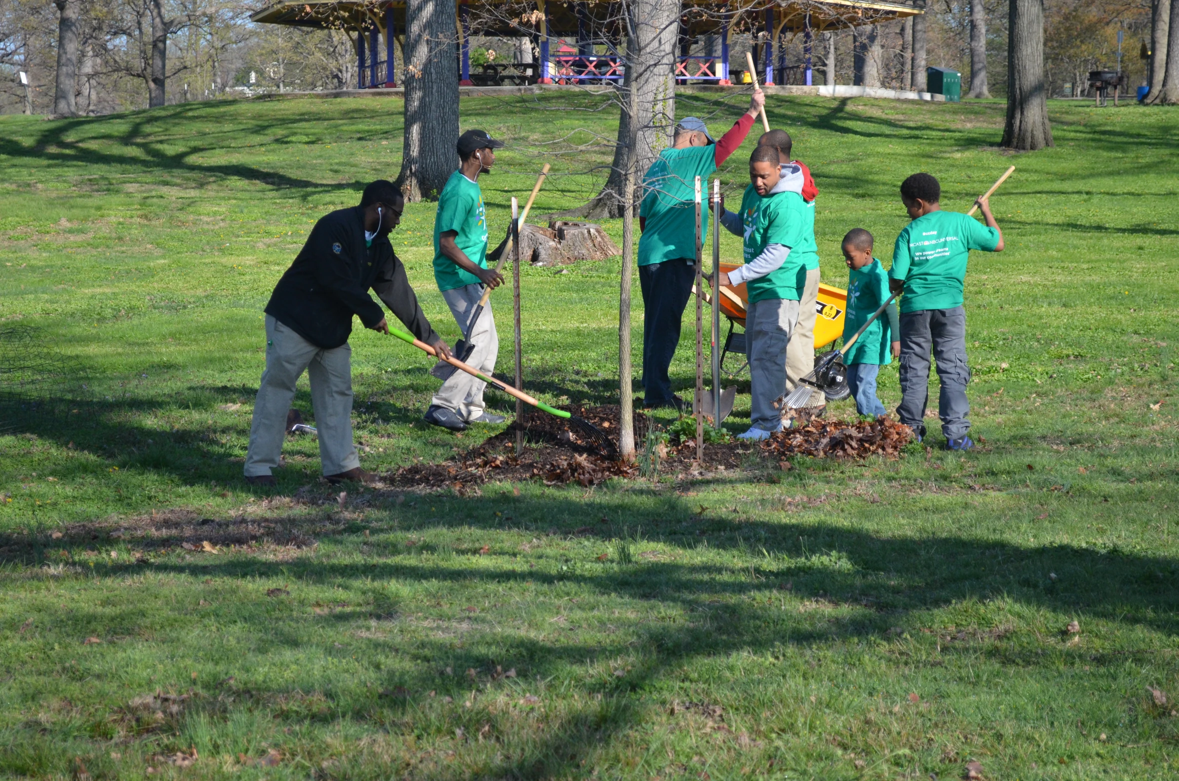 a group of children in green shirts are digging the tree