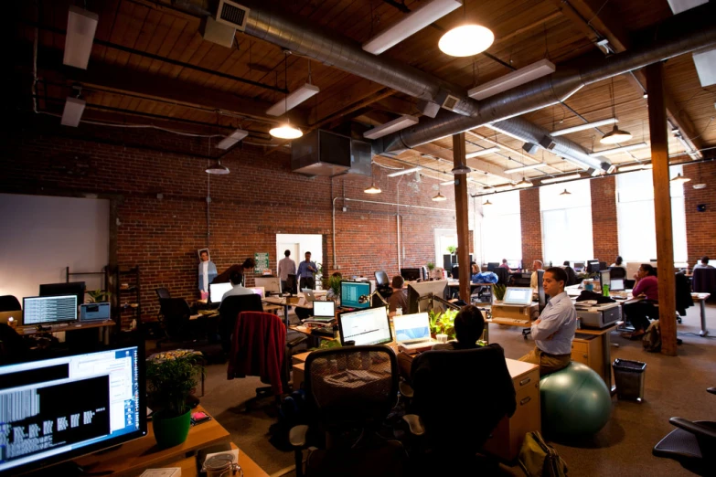 an open concept office with people sitting around