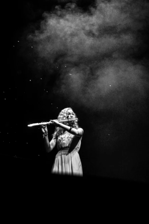 a woman holding an object in a dark sky