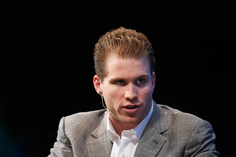 a man wearing a gray suit and white shirt