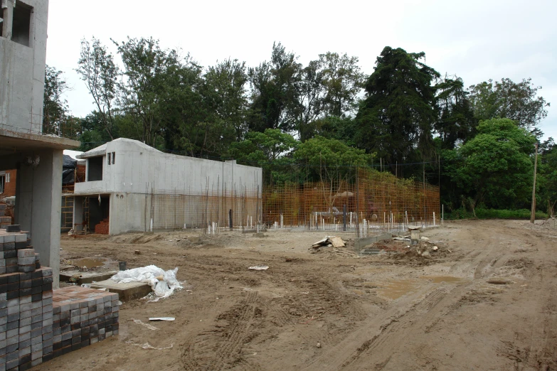 a large building sitting under construction near a forest